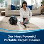 Woman cleaning carpet. Text: Our Most Powerful Portable Carpet Cleaner.