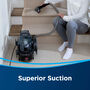Woman cleaning carpet on stairs. Text: Superior Suction.